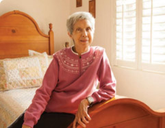 Elderly woman sitting on bed