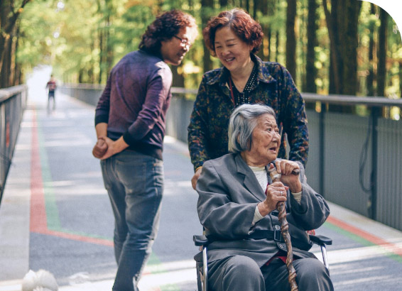 Woman pushing elderly women in wheelchair