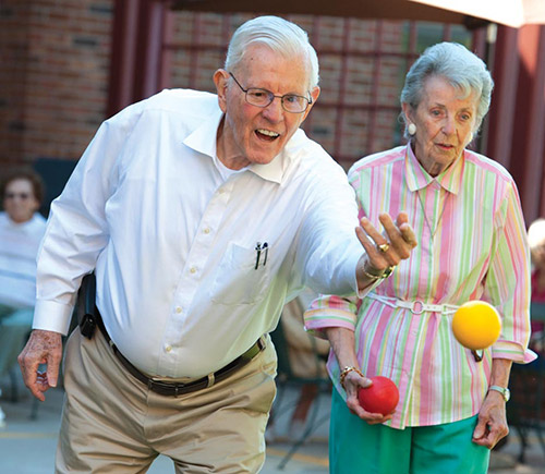 Elderly man and woman playing bocce ball